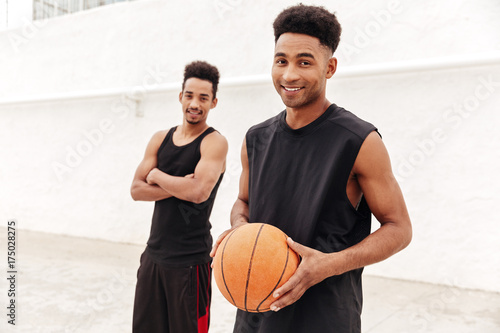 Happy young african sports men with basketball