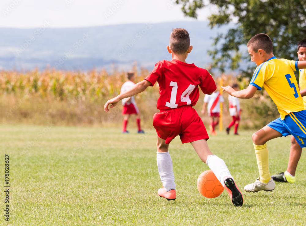 Obraz premium Kids soccer football - children players match on soccer field