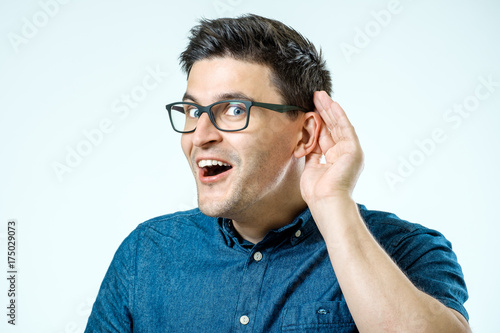 Head shot of man trying listen gossip or news. Isolated on grey background