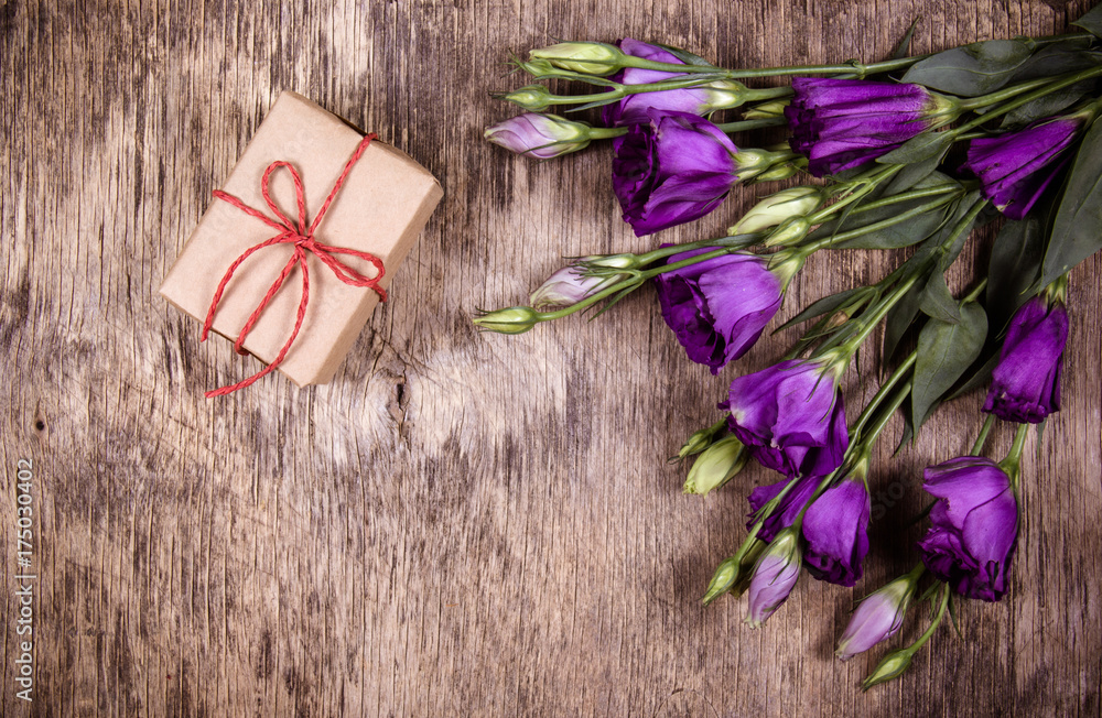 A small gift box and flowers on an old wooden background. Copy space A small gift box and flowers on an old wooden background. Copy space