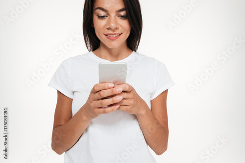 Cropped image of a young casual woman typing message