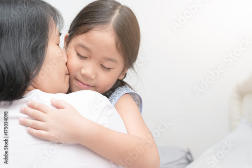 mother hugging and kiss her daughter. © kwanchaichaiudom