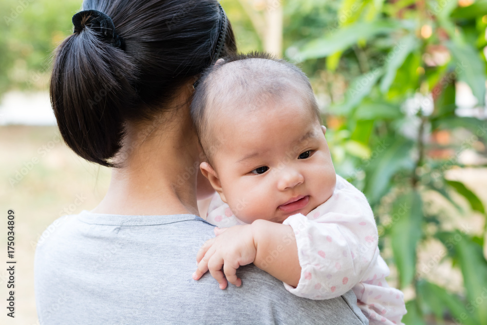 Mother holding adorable baby daughter in her arms Mother holding adorable baby daughter in her arms