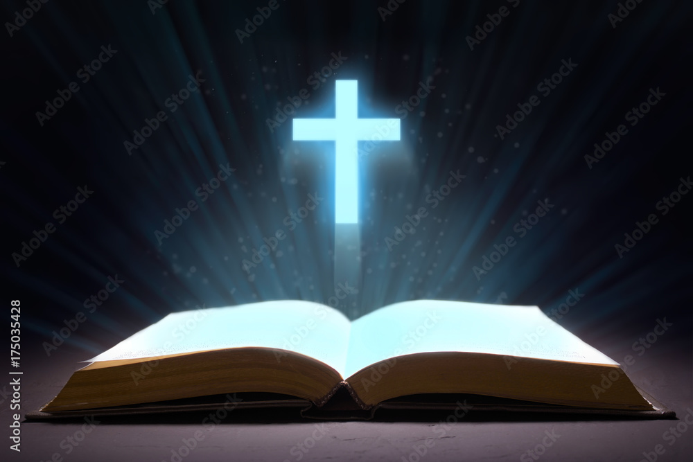 An open bible and from the book shines with rays in the form of a cross An open bible and from the book shines with rays in the form of a cross