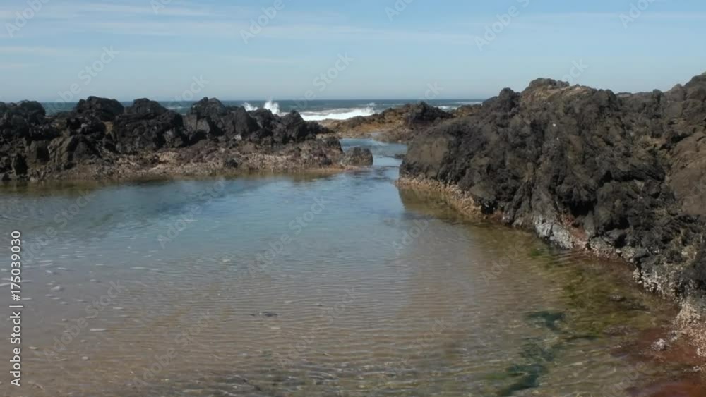 An ocean wave crashing over rocks, and then water flowing into the tide pool in the foreground. Taken along the central Oregon Coastline. An ocean wave crashing over rocks, and then water flowing into the tide pool in the foreground. Taken along the central Oregon Coastline.