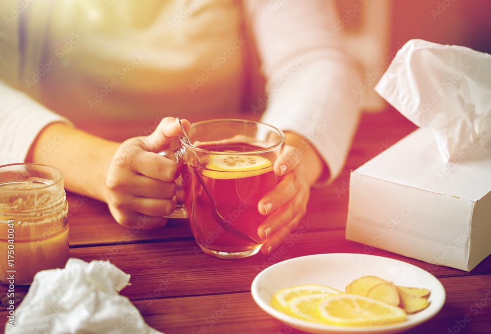close up of ill woman drinking tea with lemon close up of ill woman drinking tea with lemon