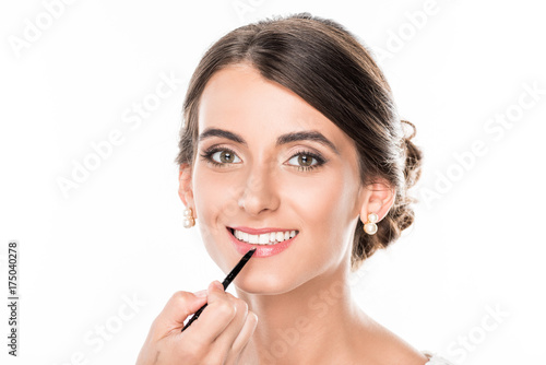 makeup artist applying lipstick on model
