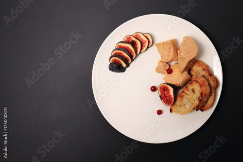 foie gras with croutons, figs and redcurrant. in a white plate, on a marble table © oleh91