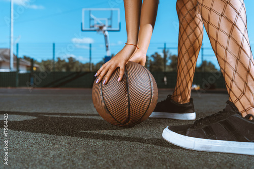 woman placing basketball on ground photo