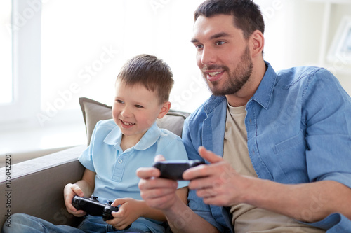 father and son playing video game at home