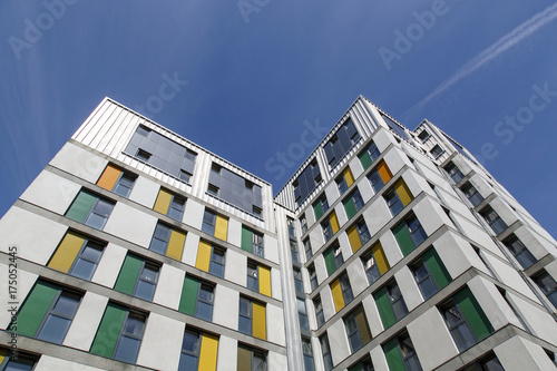 Photos Dramatic angle of a highrise building with a blue sky background