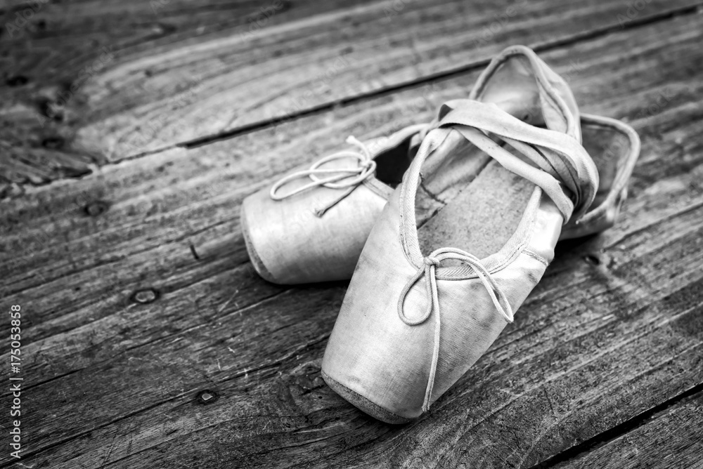 Fototapeta premium Old pink ballet shoes on a wooden floor, vintage process