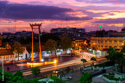 Giant swing landmark in Bangkok city in sunset time with blur moving lighting of car