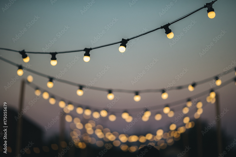 Outdoors wedding decoration with light bulbs at sunset - obrazy, fototapety, plakaty 
