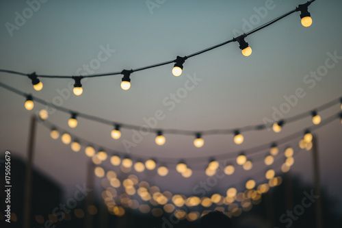 Outdoors wedding decoration with light bulbs at sunset