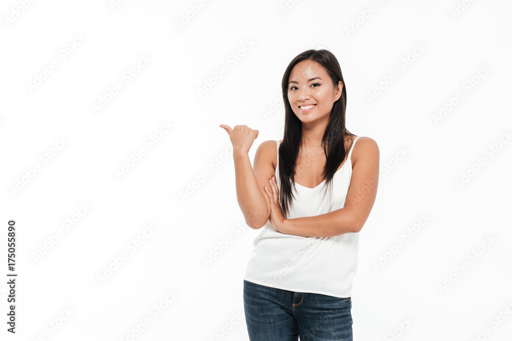 Portrait of a cheerful young asian woman pointing finger away Portrait of a cheerful young asian woman pointing finger away