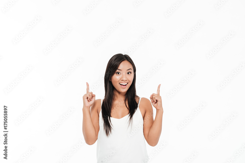 Portrait of an excited asian woman pointing two fingers up Portrait of an excited asian woman pointing two fingers up