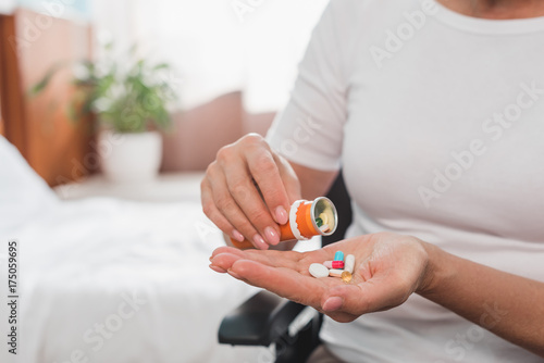 woman in wheelchair taking medicine