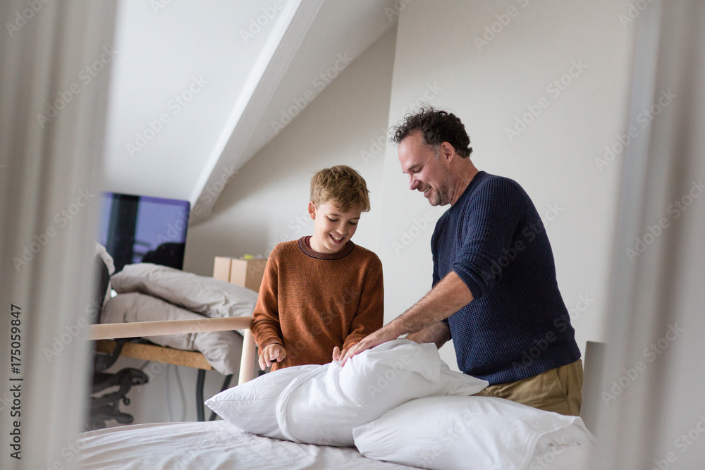 Father teaching Son how to make bed Father teaching Son how to make bed