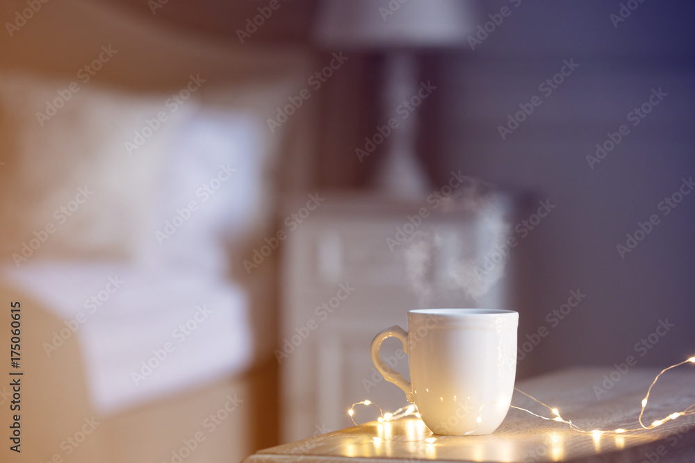 White warm cup of tea of coffee standing on wooden table White warm cup of tea of coffee standing on wooden table
