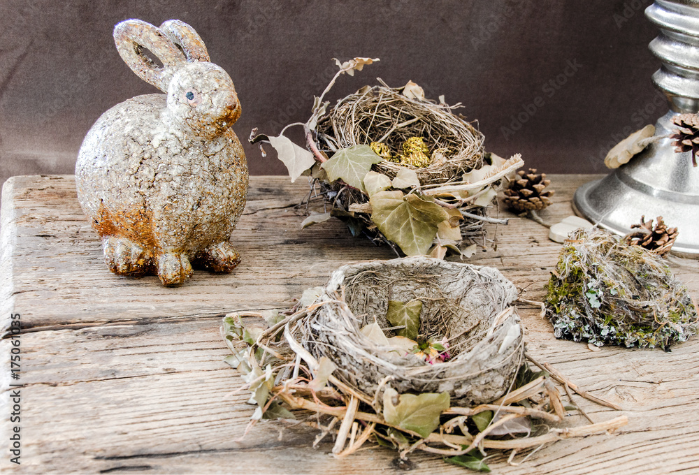 decoration with bird nests , dried flowers, and a funny,fatty,rabbit on textured old table. decoration with bird nests , dried flowers, and a funny,fatty,rabbit on textured old table.