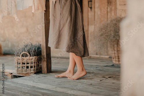 Fototapeta Naklejka Na Ścianę i Meble -  Lavender basket in a rustic courtyard near the feet of a girl
