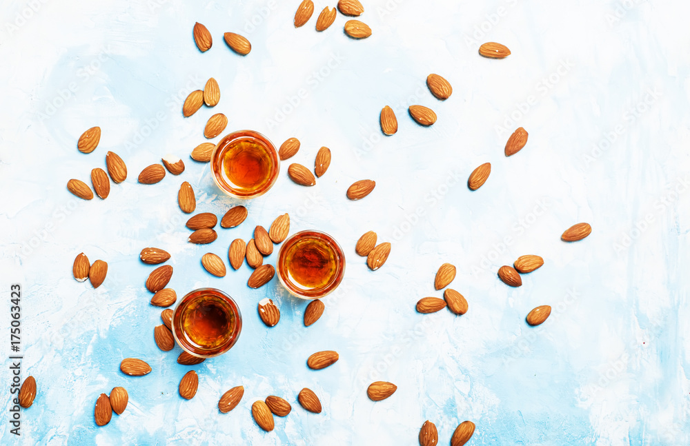 Almond liqueur with nuts on light background, top view Almond liqueur with nuts on light background, top view