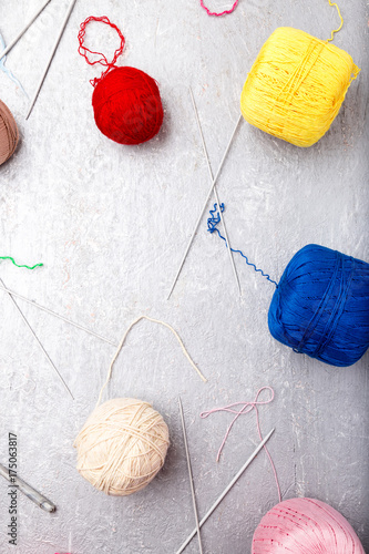 Multicolor knitting ball and needles on grey background. Top view. Copy space. Knitting yarn.