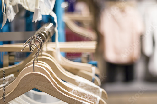 Female fashion clothing, lingerie, pajamas on hangers at the showroom, shop, store, boutique or shopping mall. Pastel colors. Close up with blurred background