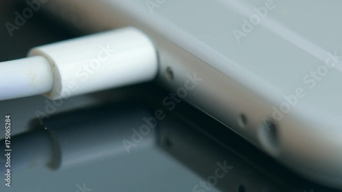 Hand plugging the charger into cell phone.