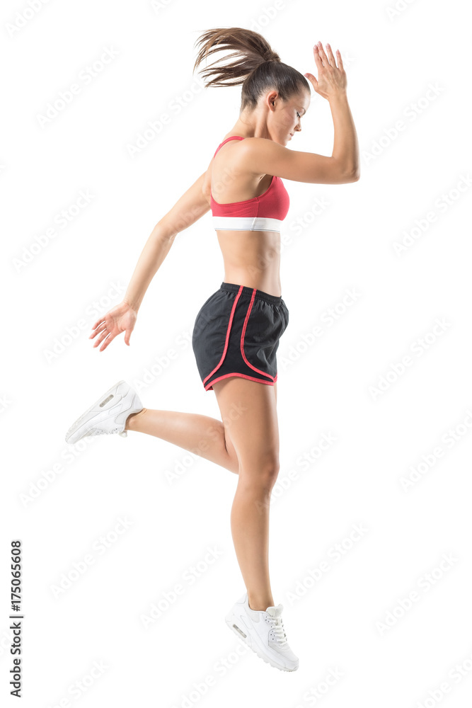 Fit active sport woman running stopped motion looking down. Full body length portrait isolated on white studio background.
