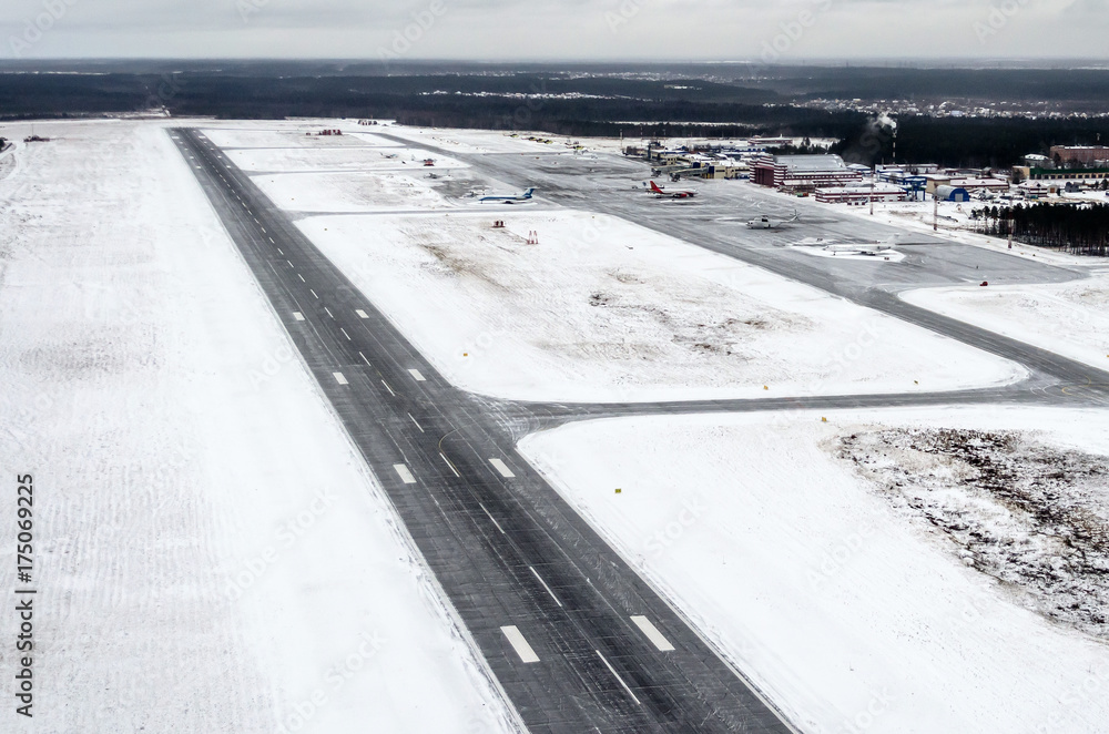 Airport and winter runway, view from a height to a snow-covered landscape.