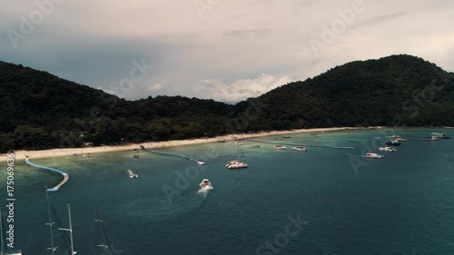 Thailand Coral Island Drone Shot Small sports boats, large catamarans, fishing schooners, active traffic near the island for the entertainment of tourists. photo