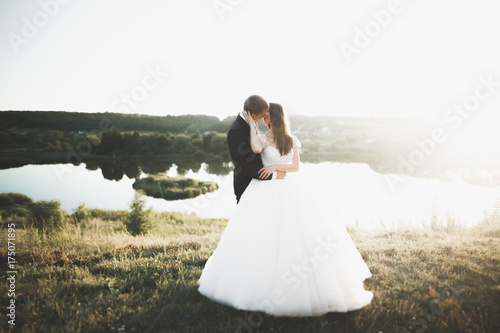 Wedding couple posing on sunset at wedding day. Bride and groom in love