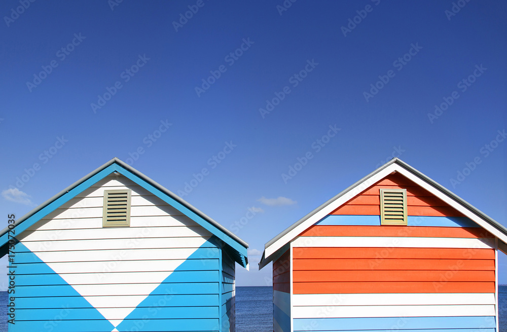 Two vibrantly painted beach huts on Melbourne's Brighton Beach Two vibrantly painted beach huts on Melbourne's Brighton Beach