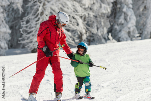 Skiing instructor with little boy