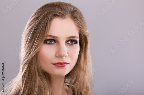 Portrait of Beautiful woman with make-up on a gray background