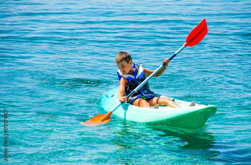 First kayaking lessons. Boy with  life buoy suit in kayak lessons during summer vacations in an island of Greece.