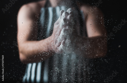 The man cook prepares flour products and meal-free flour on a glass table. Beautiful conceptual photo