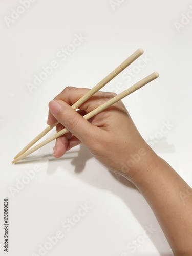Woman hand holding chopsticks on white background