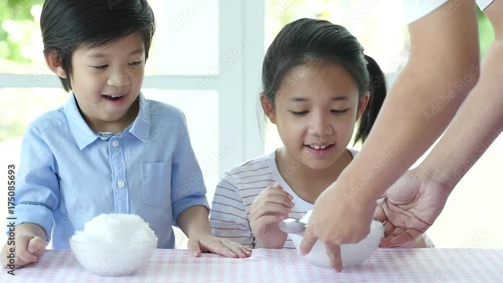 Happy little asian children  eating ice cream at home slow motion 