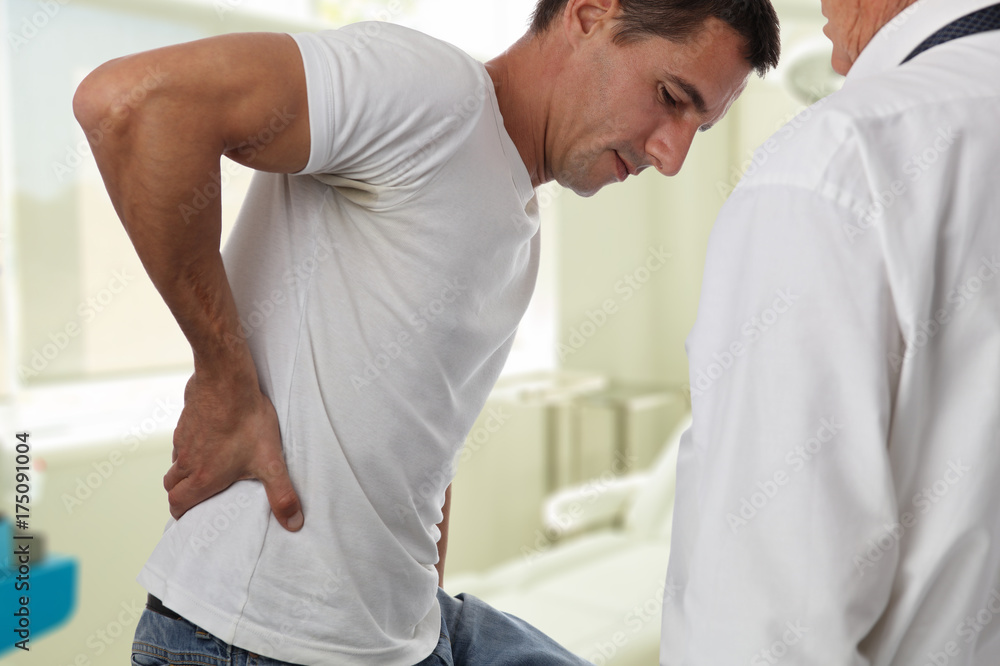 Obraz premium Muscular Man suffering from back and neck pain. Incorrect sitting posture problems Muscle spasm, rheumatism. Pain relief, ,chiropractic concept. Sport exercising injury