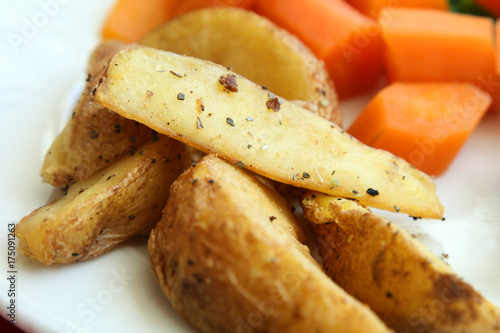 served healthy meal: baked potatoes and carrots on white plate