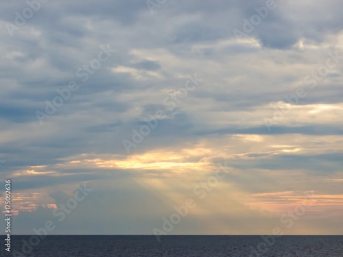White clouds with gold sunlight ray shining over the sea. © Adiroj
