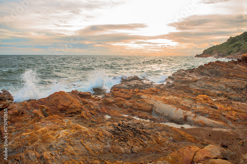 Big wave crashing on stone at sunset time