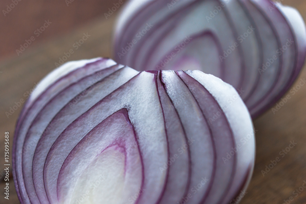 Fototapeta premium Food preparation, cooking concept: chopped and peeled fresh red onions on rustic wooden background