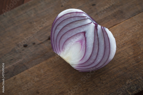 Food preparation, cooking concept: chopped and peeled fresh red onions on rustic wooden background