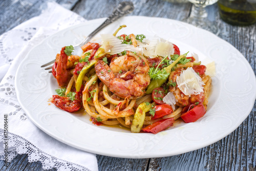 Foto Italian linguine alla gamberetti with vegetable and parmesan as close-op n a pla