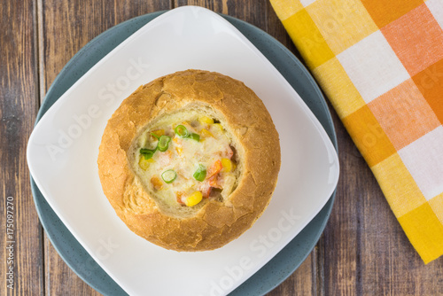 Homemade corn and cheese chowder in bread bowl.