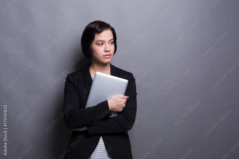 Serious woman with tablet on gray background Serious woman with tablet on gray background